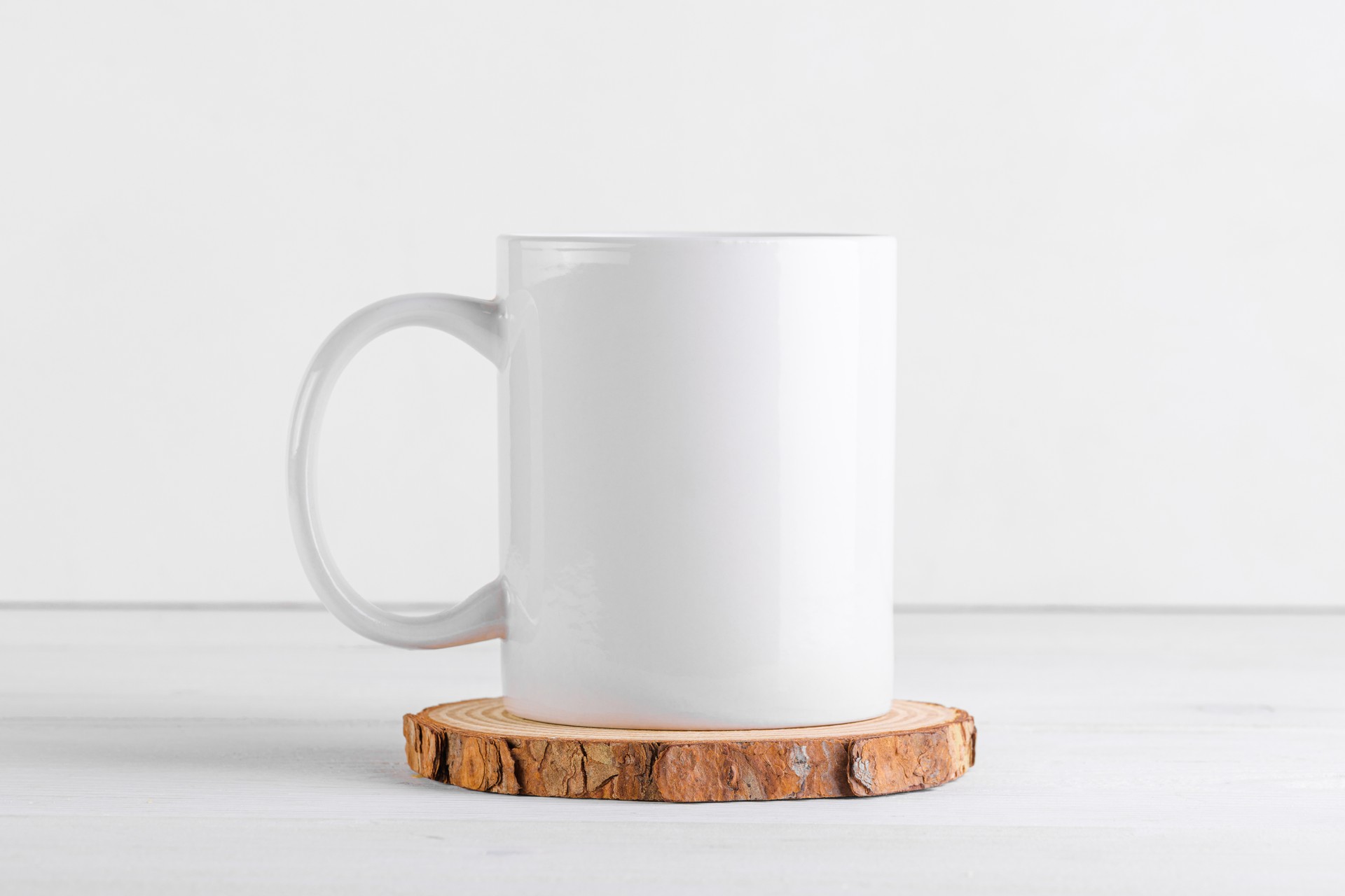 White coffee mug mockup with blank copy space on a wooden podium on white background, close up